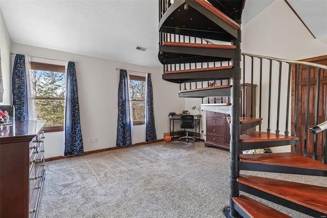 stairs featuring baseboards, visible vents, a textured ceiling, and carpet