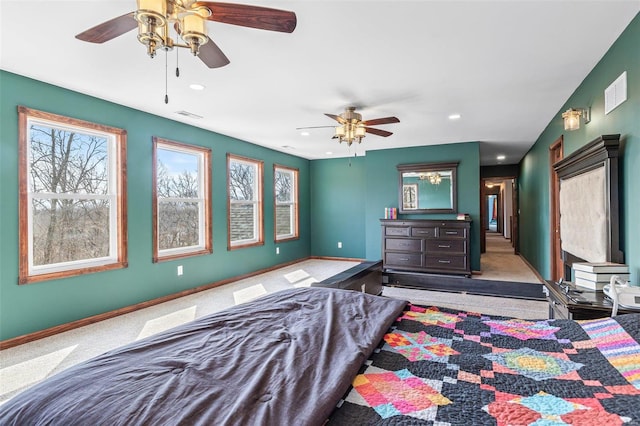 carpeted bedroom featuring multiple windows, baseboards, and visible vents