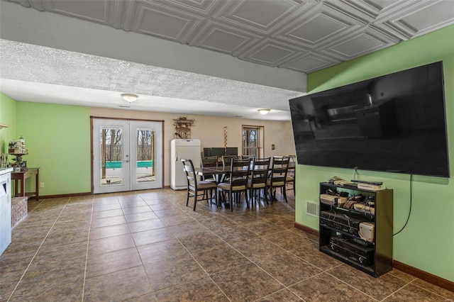 dining space with visible vents, dark tile patterned floors, french doors, and baseboards