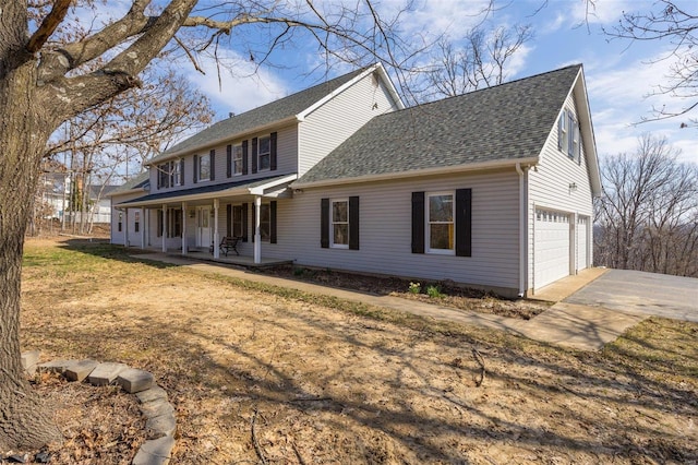 colonial inspired home featuring a garage, roof with shingles, a porch, and driveway