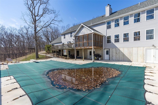 view of swimming pool with a fenced in pool, fence, a sunroom, a patio, and a diving board