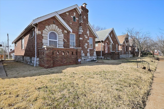 view of home's exterior featuring a yard, brick siding, and a chimney