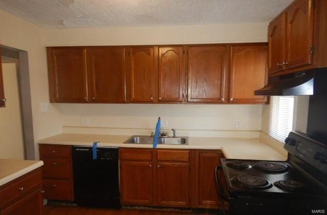 kitchen with under cabinet range hood, black appliances, light countertops, and a sink