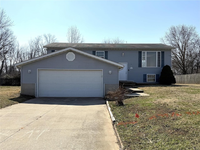 bi-level home with concrete driveway and fence