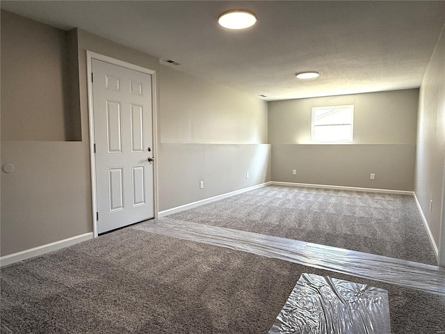 carpeted empty room featuring visible vents and baseboards