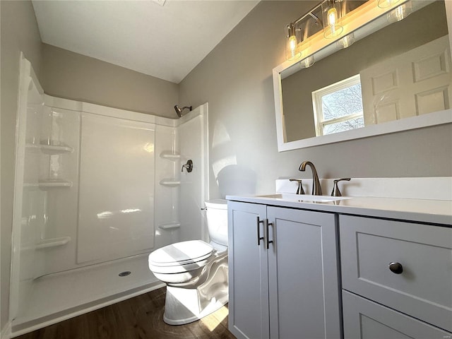 full bath featuring toilet, vaulted ceiling, wood finished floors, vanity, and a shower