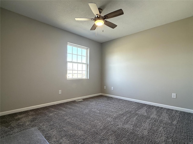 unfurnished room featuring visible vents, a ceiling fan, a textured ceiling, dark carpet, and baseboards