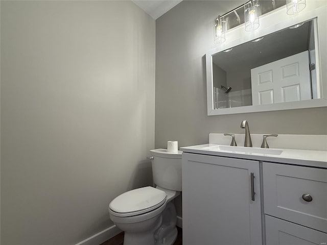 bathroom featuring baseboards, toilet, and vanity