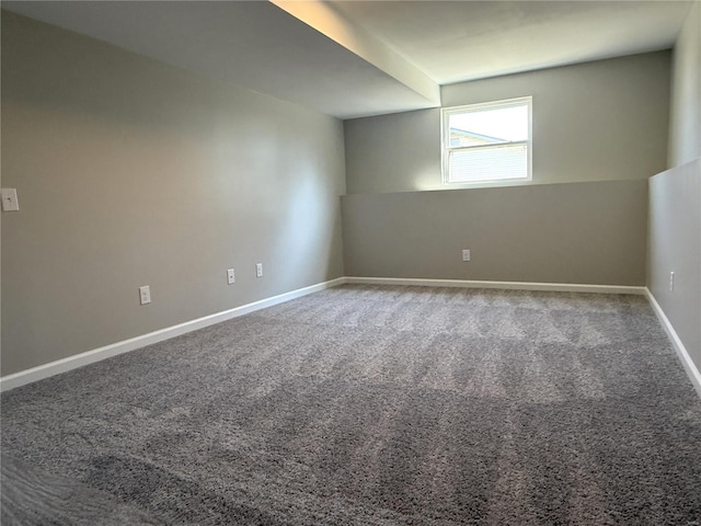 empty room featuring carpet and baseboards