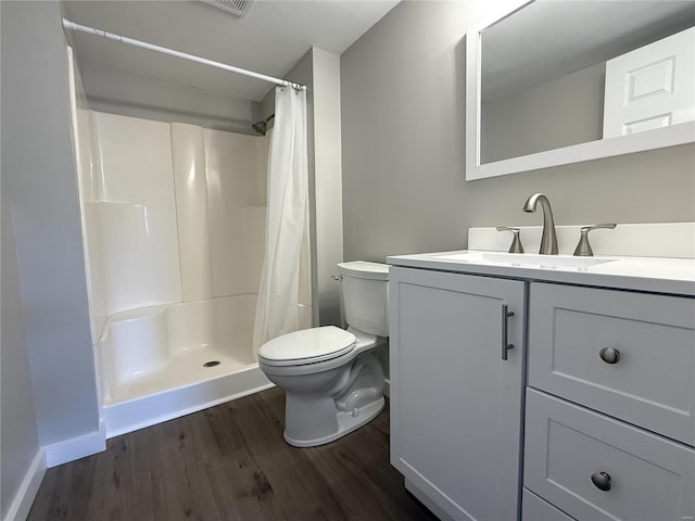 full bathroom with baseboards, toilet, a shower with shower curtain, wood finished floors, and vanity