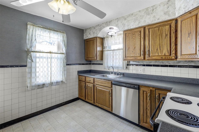 kitchen with electric range, a sink, stainless steel dishwasher, dark countertops, and brown cabinets