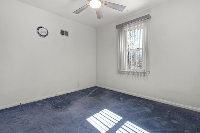 empty room with baseboards, visible vents, dark carpet, and ceiling fan