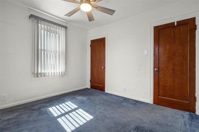 carpeted empty room with ceiling fan and baseboards