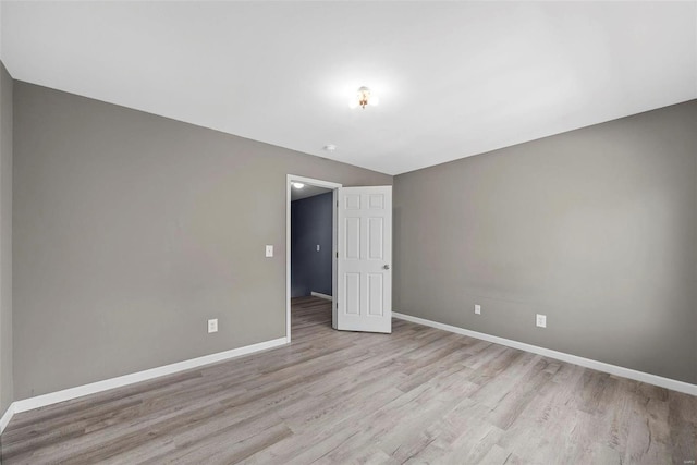 empty room featuring light wood-style flooring and baseboards