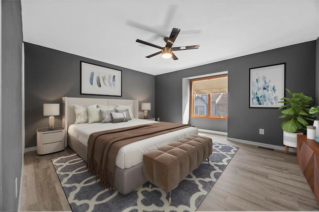 bedroom featuring visible vents, baseboards, and wood finished floors