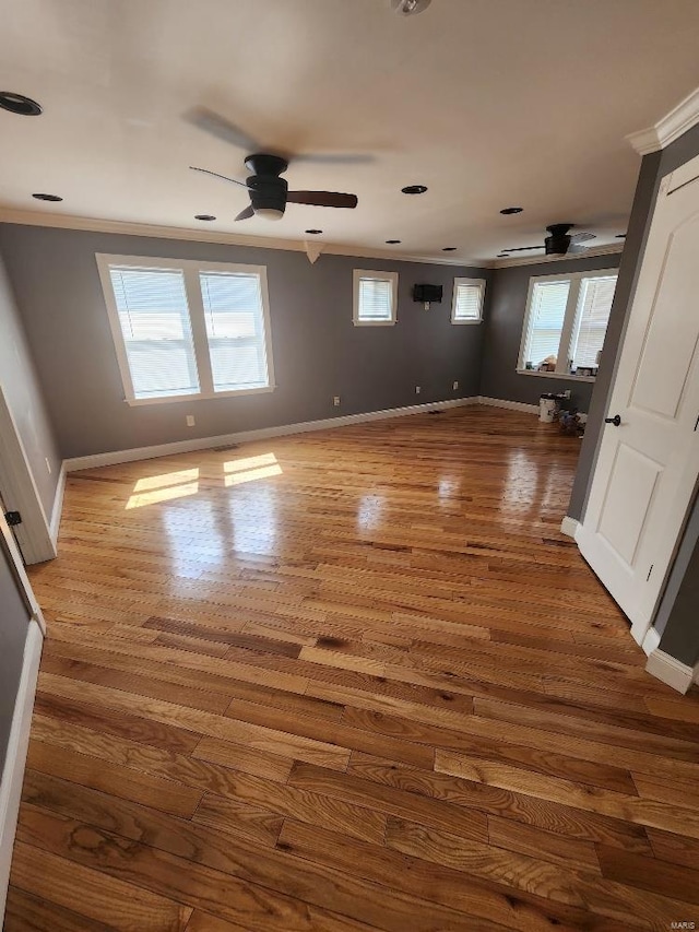 unfurnished room with dark wood finished floors, crown molding, baseboards, and ceiling fan