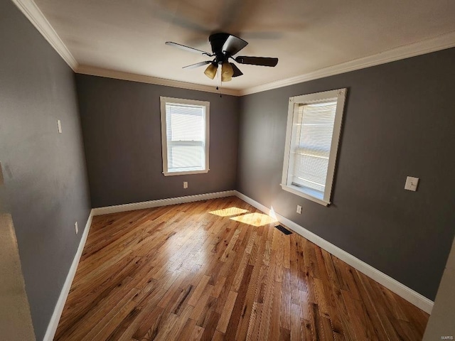 unfurnished room with visible vents, crown molding, and baseboards