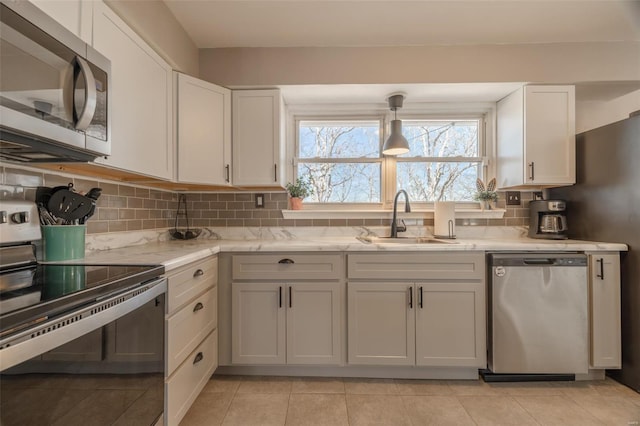 kitchen with a sink, white cabinets, tasteful backsplash, and stainless steel appliances