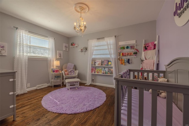 bedroom with a notable chandelier, baseboards, and wood finished floors