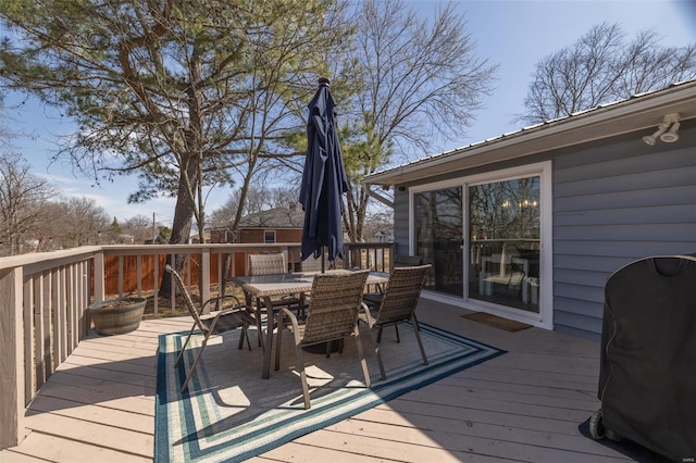 deck with outdoor dining space and area for grilling