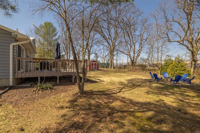 view of yard with an outbuilding, a storage unit, and a wooden deck