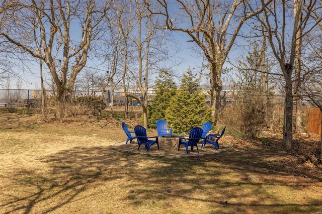 view of yard featuring an outdoor fire pit and fence