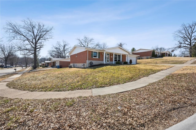 view of front of property featuring a front lawn, an attached garage, and brick siding