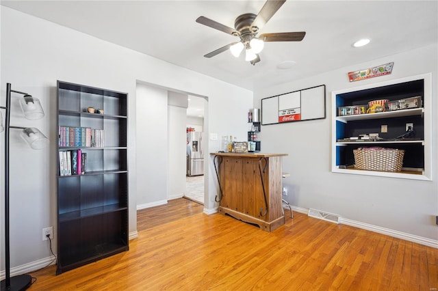 bar featuring visible vents, stainless steel fridge, baseboards, and wood finished floors