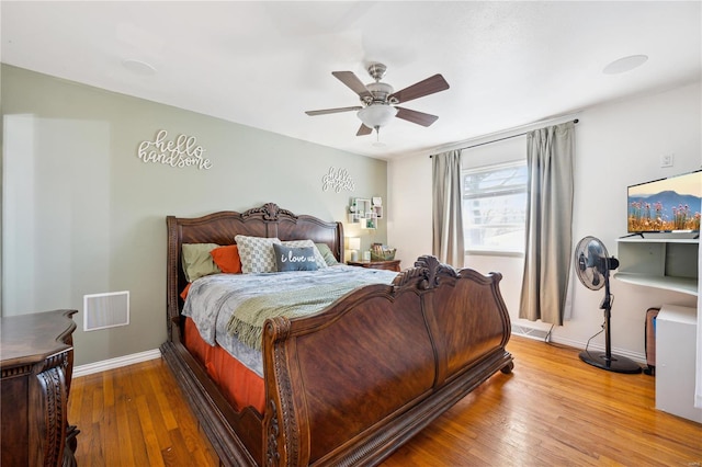 bedroom with visible vents, ceiling fan, baseboards, and hardwood / wood-style floors