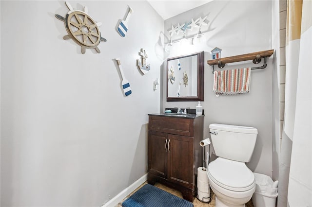 full bath with toilet, vanity, and baseboards