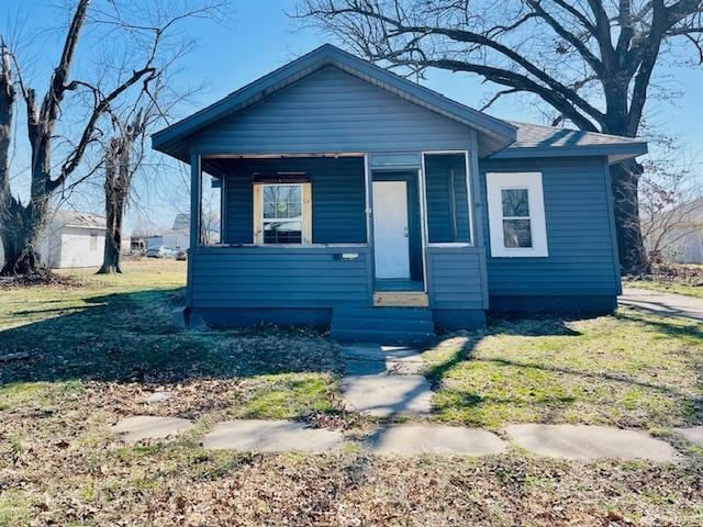 bungalow-style home with a front lawn