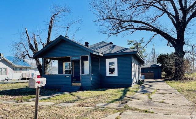 bungalow-style house with an outdoor structure and a front yard