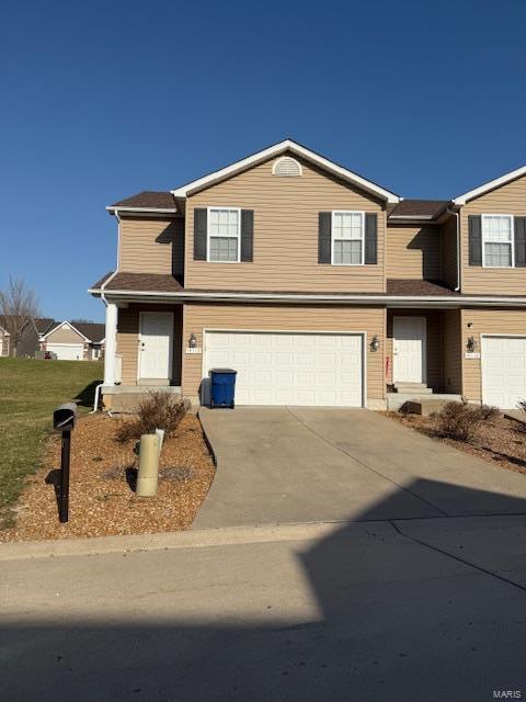 traditional home with concrete driveway and an attached garage