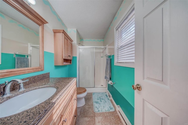 bathroom with vanity, a shower stall, a textured ceiling, a baseboard heating unit, and toilet