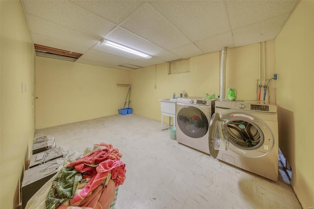 laundry area with laundry area, separate washer and dryer, and a sink