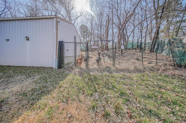 view of yard featuring an outbuilding, a gate, and fence