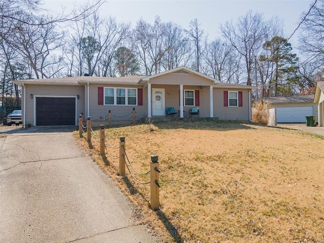 ranch-style house featuring aphalt driveway, a garage, covered porch, and a front yard