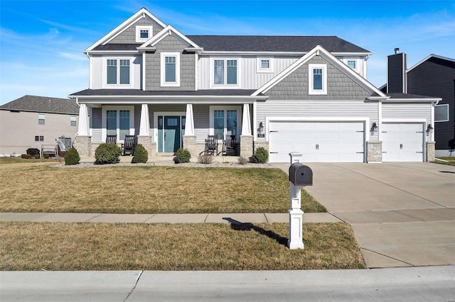 craftsman house featuring stone siding, a porch, driveway, and a front yard