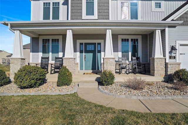 entrance to property featuring stone siding, board and batten siding, and a porch