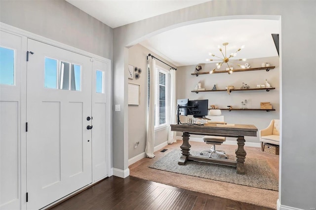 entryway with arched walkways, an inviting chandelier, baseboards, and wood finished floors