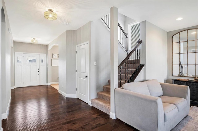 foyer entrance featuring baseboards, recessed lighting, arched walkways, stairs, and hardwood / wood-style flooring