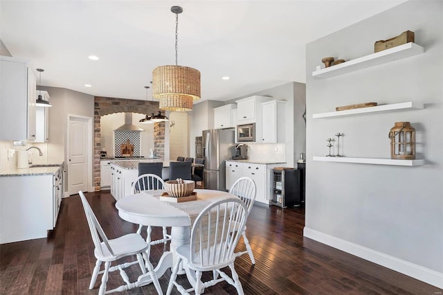 dining area featuring recessed lighting, baseboards, dark wood-style flooring, and arched walkways