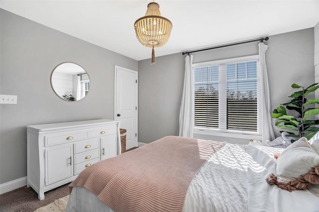 bedroom with baseboards, light carpet, and a chandelier