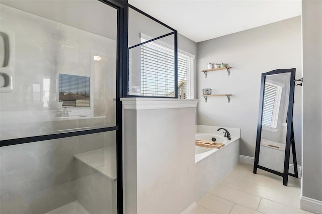 bathroom with baseboards, a bath, a shower stall, and tile patterned flooring