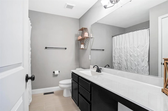 bathroom featuring vanity, toilet, baseboards, and visible vents