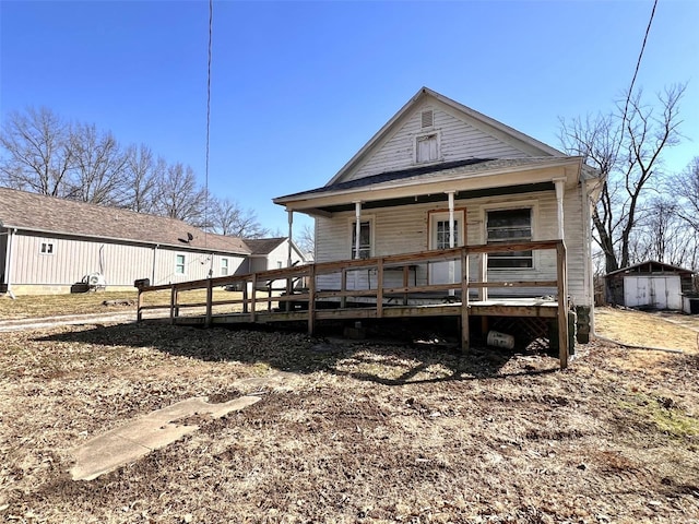 back of house featuring an outbuilding and covered porch