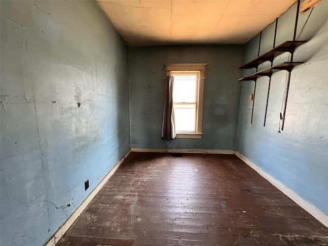 empty room featuring hardwood / wood-style flooring and baseboards