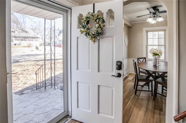 entrance foyer featuring ceiling fan, wood finished floors, and ornamental molding