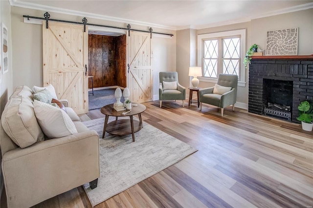 living area with a barn door, wood finished floors, and crown molding