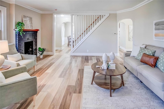 living room with wood finished floors, arched walkways, and ornamental molding